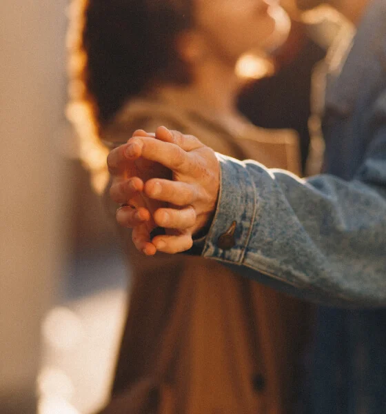 A close-up of a couple's interlocked hands, symbolizing connection and partnership.
